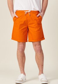 Pantaloni shorts arancioni realizzati in tessuto leggero, con vita regolabile, tasche laterali e orli arrotolati per un look casual.