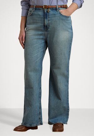 Lichtblauwe wijde jeans met een hoge taille, met twee voorzakken, riemlussen en een licht vervaagde textuur. Bruine schoenen maken de look compleet.