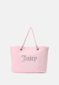 Roza bombažna torba z vstavljenim logotipom 'Juicy', srebrnimi luknjicami in dvema ročkama za enostavno nošenje. Gladka tekstura in prostoren dizajn.
