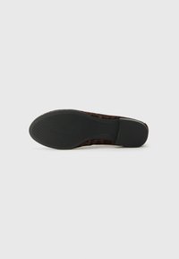 Zapato plano de estampado de leopardo con parte superior de tela suave, puntera redondeada y suela de goma negra texturizada. Presenta acentos de hardware mínimos.