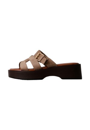 Sandale mule en daim marron avec semelle plateforme épaisse en bois et boucle dorée sur les brides latérales.
