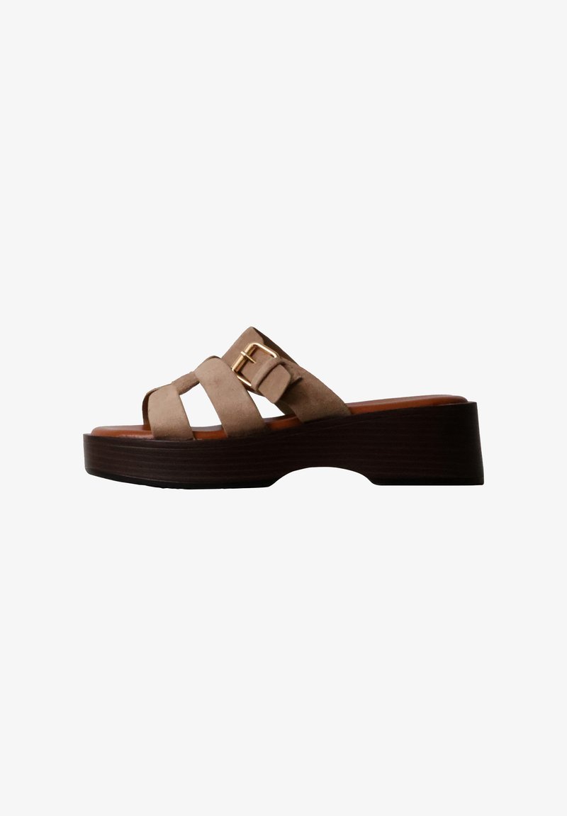 Sandale mule en daim marron avec semelle plateforme épaisse en bois et boucle dorée sur les brides latérales.