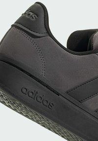 Czarne zamszowe sneakersy z teksturowaną gumową podeszwą, z gładkim czarnym akcentem z logo oraz wzmocnioną piętą dla lepszej podparcia.