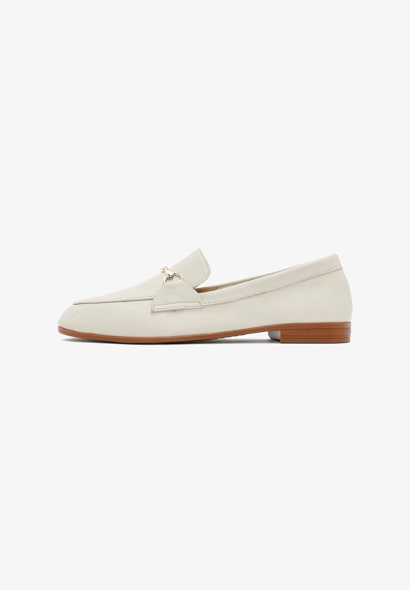 Cream-colored leather loafers with a flat, brown sole. Features a front flap and a small gold accent on the side. Smooth texture, minimal design.