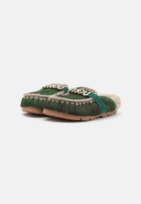Green fur slippers with beige shearling lining, braided trim, and gold-tone "miu miu" logo. Rubber sole for traction. Rounded shape.
