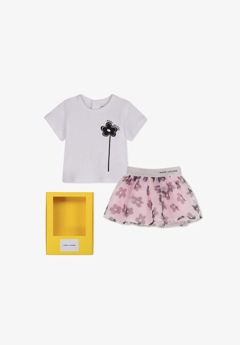 Chemise blanche à manches courtes avec imprimé de fleurs noires et jupe en tulle à motif de fleurs roses avec taille argentée Marc Jacobs, à côté d'une boîte jaune.
