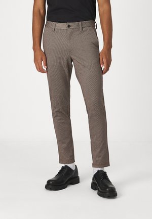 Brown checkered pants made from lightweight fabric, featuring a straight fit, and paired with black shoes and white socks.