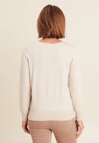 Hellbeige Pullover mit langen Ärmeln, Rundhalsausschnitt und Rippstruktur am Saum und an den Bündchen. Glattes, weiches Material.
