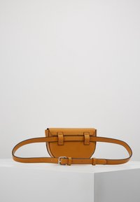 Mała pomarańczowa skórzana torebka na ramię o prostokątnym kształcie, regulowanym pasku i dwóch klamrach z przodu. Gładka faktura.