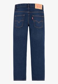 Tummansiniset suorat farkut, joissa on nahkainen vyötärönauhapala ja kaksi suorakaiteen muotoista takataskua, joissa on koristetikkaukset.