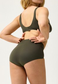 Set da bagno verde oliva composto da un bralette aderente con spalline larghe e slip a vita alta, realizzato in un tessuto liscio ed elasticizzato.