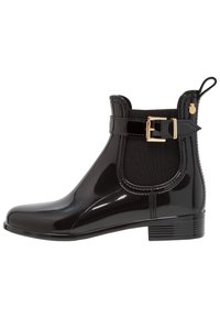 Bottines noires brillantes avec panneaux latéraux élastiques, accent de boucle et semelle en caoutchouc texturée. Équipées d'une languette de tirage pour un enfilage facile.
