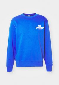 Blå sweatshirt gjord av bomullsblandning, med rund hals, långa ärmar och en vit Nike Sportswear-logotyp på bröstet.