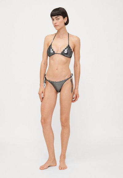 Metalna črna bikini s trikotno zgornjim delom in dekorativnim čipkastim obrobjem. Povezovanje ob strani spodnjega dela omogoča prilagodljivost. Gladka tekstura.