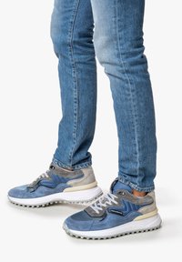 Siniset tennarit, joissa on sekoitus materiaaleja, kuten nubukkia ja verkkoa, harmailla yksityiskohdilla, pehmustettu valkoinen pohja ja näkyvät nauhoitukset.