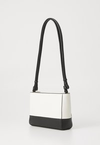 Small rectangular bag with a white upper section and black bottom. Features a smooth finish, adjustable black strap, and minimal stitching.