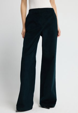 Weite Cordhosen in tiefem Türkis mit glatter Oberfläche, vorne mit Knopfverschluss und Seitentaschen.