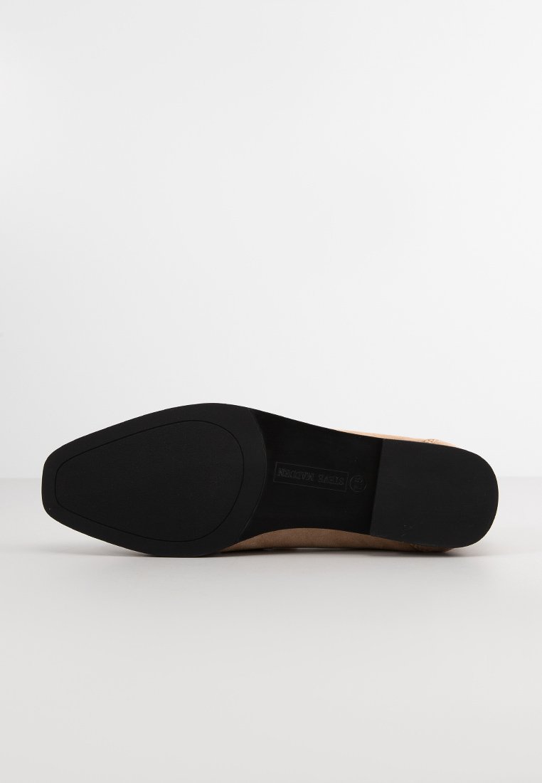 Beige High Heel mit einem glatten Leder-Obermaterial. Die Sohle ist aus schwarzem Gummi mit einer strukturierten Oberfläche und einem spitzen Zehendesign.