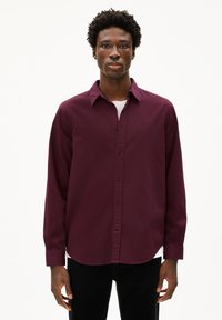 Camicia a maniche lunghe bordeaux con colletto classico, caratterizzata da un piccolo logo sul petto e da un tessuto morbido e leggero.