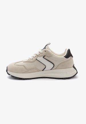 Beige Sportausführung aus Wildleder und synthetischem Material. Verfügt über schwarze Akzente, ein weißes Logo, eine runde Zehenpartie und eine strukturierte Sohle. Schnürsenkel vorne.