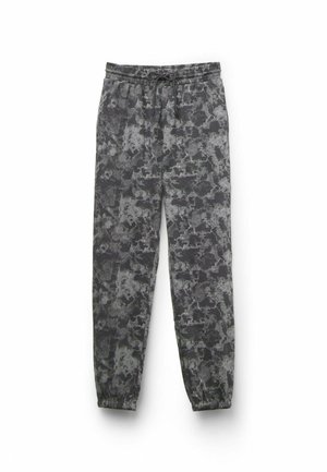 Pantalones de chándal grises con un patrón abstracto en negro y plata, cintura elástica con cordón y puños elásticos en los tobillos.