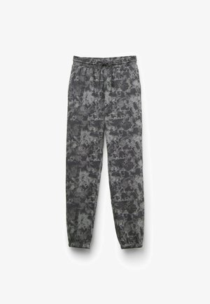 Pantalones de chándal grises con un patrón abstracto en negro y plata, cintura elástica con cordón y puños elásticos en los tobillos.
