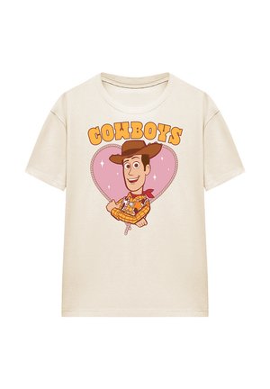 Beige T-shirt with cartoon cowboy wearing a hat and checked shirt inside a heart-shaped rope design, text "COWBOYS" above.
