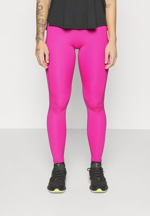 Leggings ajustés taille haute de couleur rose vif, fabriqués en matériau extensible. Associés à des chaussures de sport noires avec des accents verts.