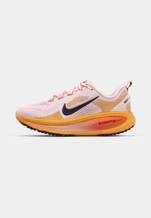 Zapatilla deportiva de color rosa claro con swoosh negro, acentos naranjas, parte superior de malla, collar acolchado y amortiguación ZOOMX, diseñada para la comodidad y el rendimiento.