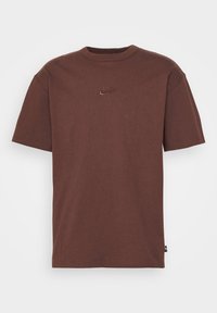 Hnědé bavlněné tričko s kulatým výstřihem a krátkými rukávy, se vyšívaným logem Nike na hrudi.