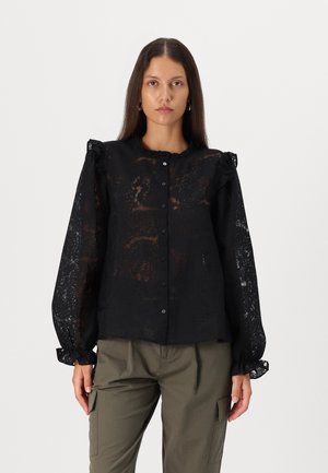 Black lace blouse with long, puffed sleeves, ruffled collar, and buttons down the front; sheer material with textured floral patterns.