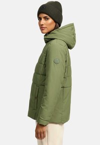 Olijf groene gewatteerde jas met een capuchon, voorzien van een logo patch, rits aan de voorzijde en zijzakken. Gecombineerd met een bijpassende gebreide muts.