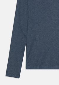 Langermet ribbestrikket plagg i heatheret blå, som viser ermet og sidesømmen på en hvit bakgrunn.