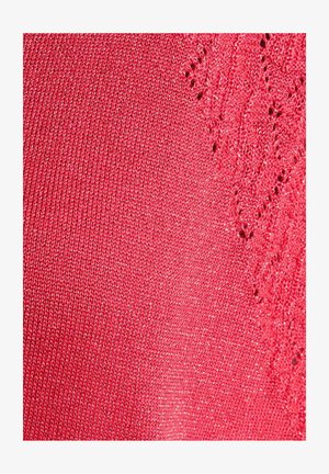 Tessuto rosso lavorato a maglia con sottili fili glitterati e motivo in pizzo sul lato destro, che mostra la trama e i dettagli intricati.