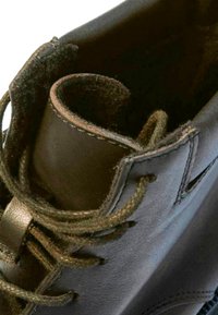 Brauner Lederstiefel mit abgerundeter Oberseite, strukturiertem Innenraum und olivgrünen Schnürsenkeln. Verfügt über eine gestickte Detail entlang der Kanten und Ösenlöcher.