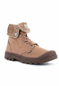 Bottines en toile marron avec un revers replié, un design à lacets, une semelle en caoutchouc et un logo circulaire sur le côté.  Bout renforcé pour une durabilité accrue.