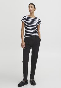 Randig topp i marinblått och vitt med kort ärm, i kombination med svarta skräddarsydda byxor och svarta stövleter i chunky stil, med en slät textur och slim fit.