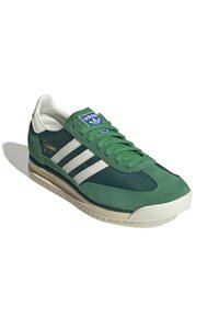 Zapatillas de ante verde y malla con rayas blancas, punta redonda, suela texturizada y un parche con logo azul en la lengüeta.