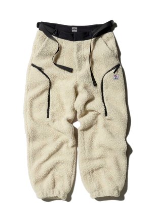 Fleecebukser i off-white med en blød tekstur, der har to sidelommer, justerbar talje og kontrasterende sorte hardware-detaljer.