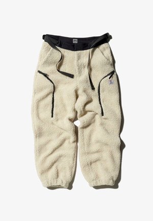 Fleecebukser i off-white med en blød tekstur, der har to sidelommer, justerbar talje og kontrasterende sorte hardware-detaljer.