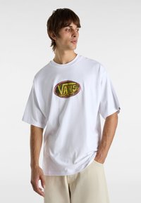 Witte oversized t-shirt van katoen, voorzien van een kleurrijke ovale Vans-logo op de borst en korte mouwen. Effen achtergrond.