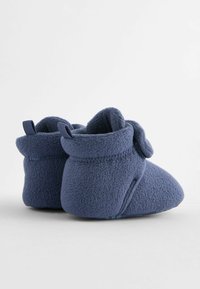 Lämpimät, tummansiniset fleece-tossut taitetulla resorilla, jossa on nauhakiinnitys sivussa, ja pehmeä tekstiili mukavuutta varten.
