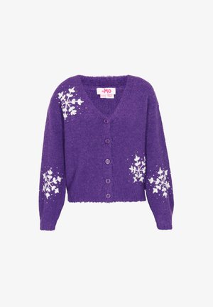Lila kötött kardigán, V-nyakkal, fehér hópehelymintákkal az ujjakon és egy sor illő gombbal az elején.