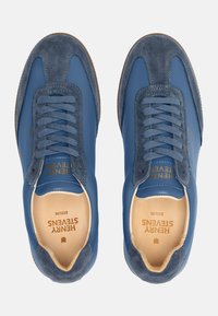Baskets en cuir bleu et en daim avec des bouts ronds, lacets assortis et marquage en relief doré. Doublure intérieure douce et semelles en caoutchouc marron.