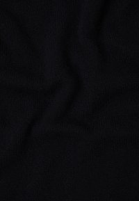 Tessuto lavorato a maglia nera con una superficie morbida e testurizzata. L'aspetto sgualcito rivela una qualità accogliente e calda, adatta per l'abbigliamento.