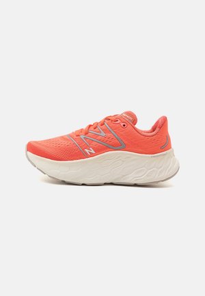 Bright coral running shoe with thick white textured sole, breathable mesh upper, and gray "N" logo on side, viewed from the outer side.