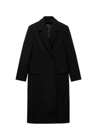 Zwarte lange jas van gestructureerde stof, met een geknipt kraag, sluiting met een enkele knoop en twee voorzakken. Eenvoudige, rechte silhoeet.