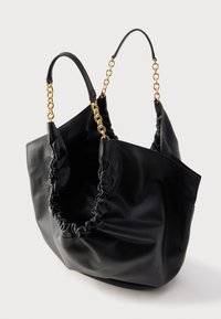 Zwarte leren handtas met geplooide zijkanten en handvatten van gouden schakels, afgebeeld tegen een effen witte achtergrond.