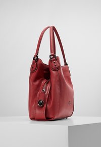 Sac à bandoulière en cuir rouge avec une surface texturée, deux poignées assorties et une poche latérale zippée. Présente un petit logo en accent.