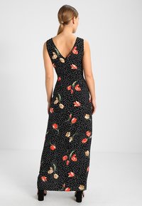 Černé maxi šaty s puntíky, V-zadním výstřihem, květinovými vzory v červené a béžové barvě a přiléhavým pasem. Hladká tkanina s volným střihem.